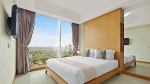 Een moderne hotelkamer met een groot bed, een televisie en uitzicht op de stad.