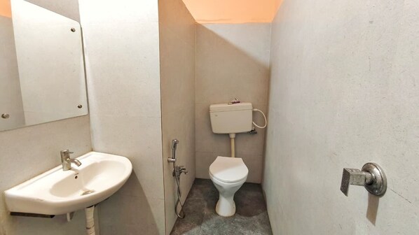 Un baño pequeño y funcional, con lavamanos, inodoro y ducha.