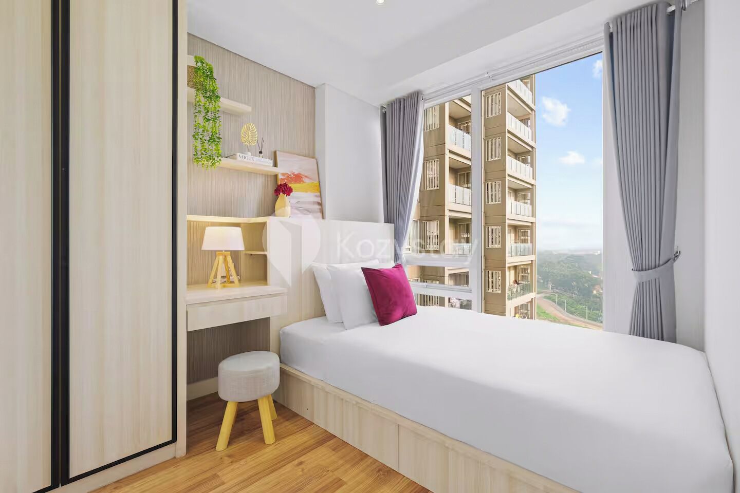 A modern bedroom with a bed, a desk, and a view of a building.