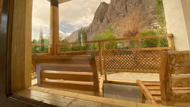 Un balcón de madera con vistas a un paisaje montañoso.