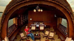 A boat with a thatched roof, a dining area, and a seating area with a view of the water. - Eco House Boats - Alleppey Kerala (Alappuzha)