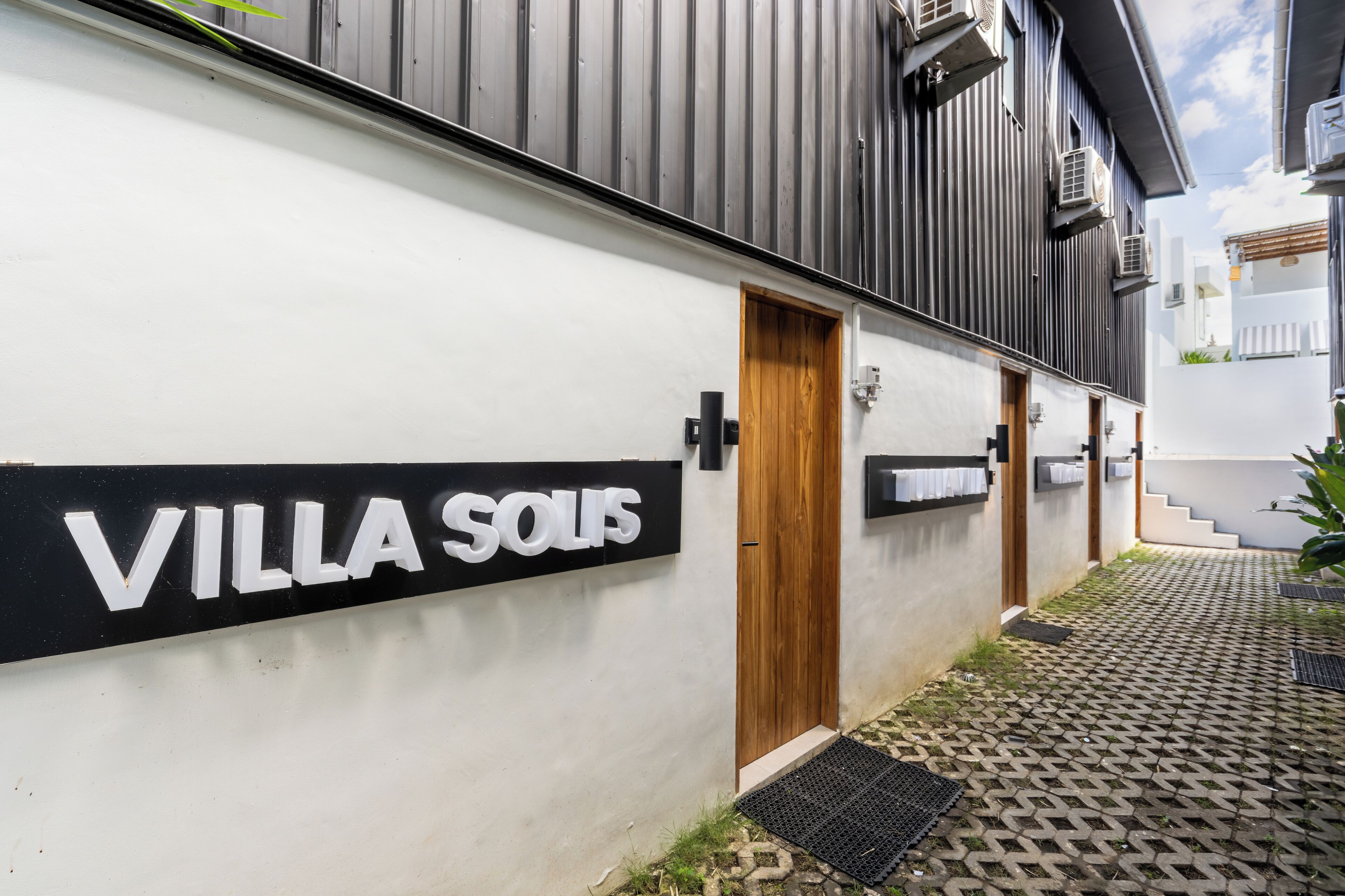 A modern villa with a sign reading "VILLA SOULIS" on the exterior wall.