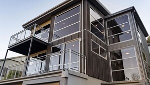 A modern multi-story building with large windows and balconies. - Mountain Views on Sainsbury (Queenstown)