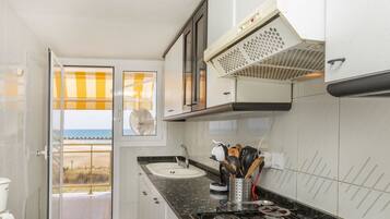 Een koelkast, een magnetron, een oven, kookgerei, borden en bestek