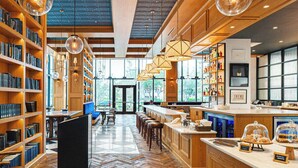 A modern library with bookshelves, a coffee bar, and a bar area.