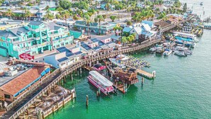 A coastal town with colorful buildings, a pier, and boats.