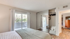 A bedroom with a large bed, a walk-in closet, and a sliding glass door to the balcony. - 2 Mi to Downtown: Gated Condo in Palm Springs (Palm Springs)