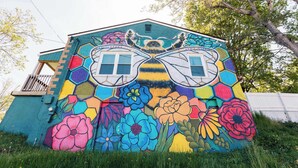 Un mural colorido en un edificio con un diseño de ventana hexagonal.