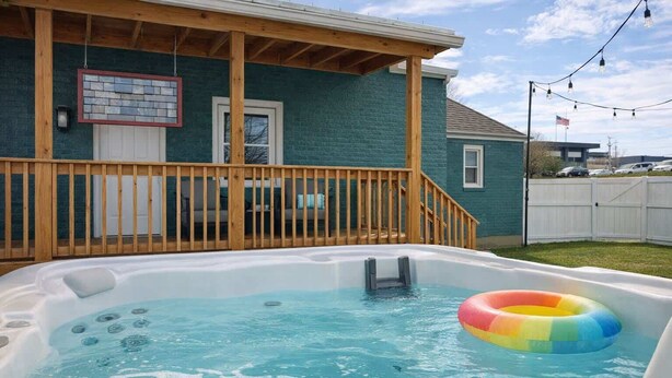 Un jacuzzi con cubierta de madera y un aro inflable de colores.