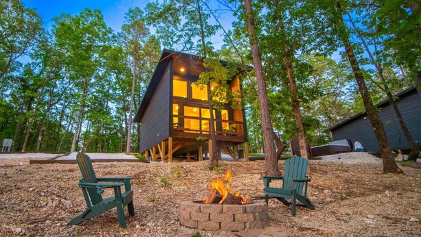 A cabin with a fire pit and two Adirondack chairs in a wooded area. - 2 Cabins, Hot Tub, 3 mi to BNR (Jasper)