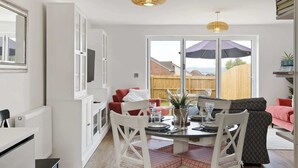 Una cocina moderna con comedor, ventanas amplias y vista al patio trasero.