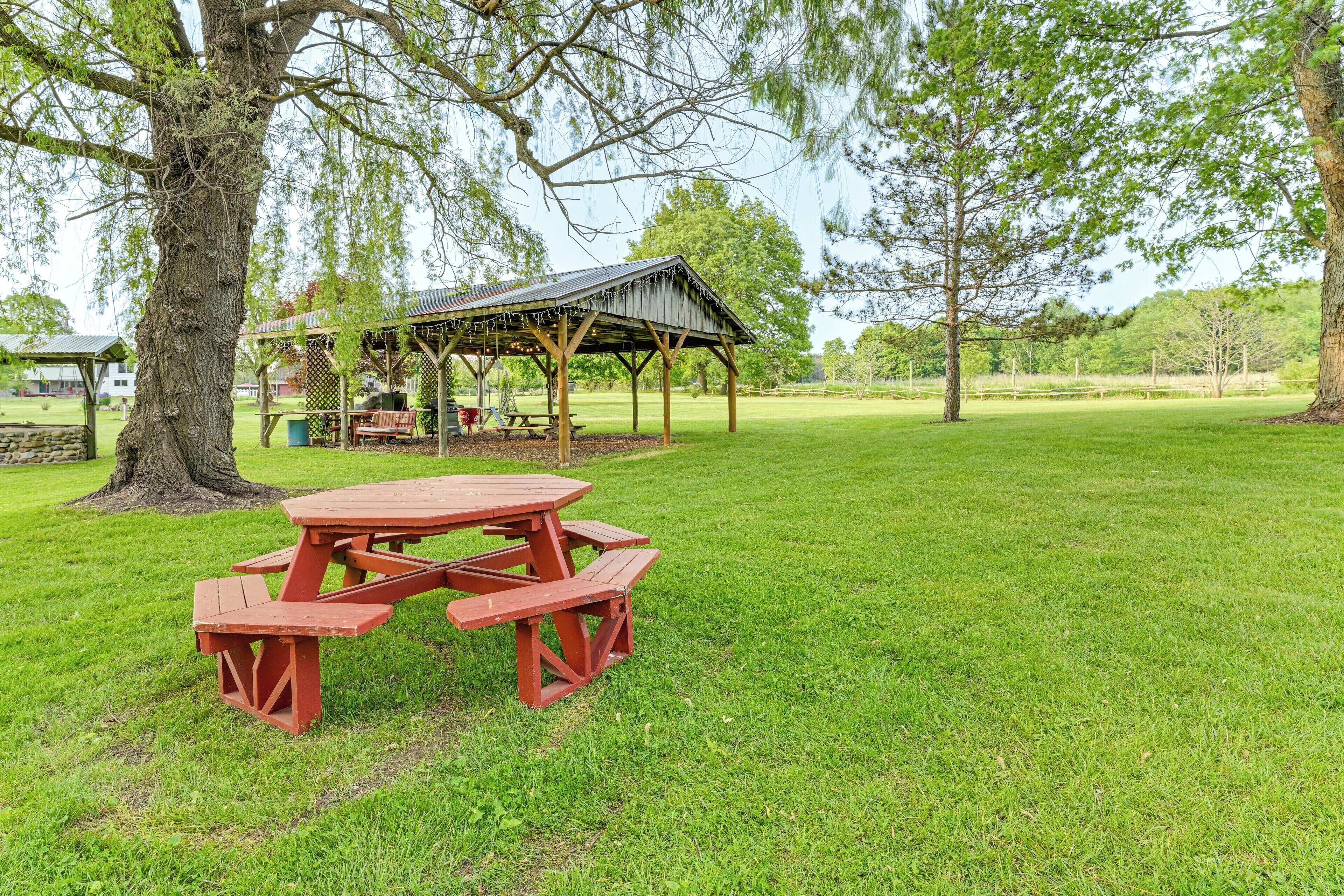 Una mesa de picnic con bancos en un parque cubierto de césped.