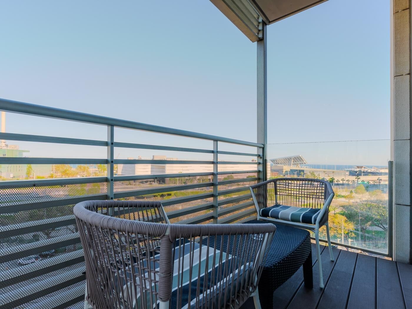 Een balkon met rieten meubilair en uitzicht op de stadszicht.