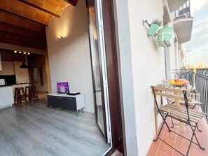 Eine moderne Wohnung mit Küche, Essbereich und einem Balkon mit Tisch und Stühlen.