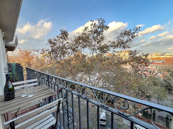 Un balcon donnant sur des arbres et des immeubles.