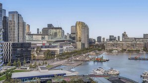 A cityscape with modern buildings, a marina with boats, and a bridge. - Docklands Waterfront Elegance with Cityscape Views (Docklands)
