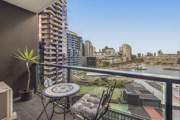 A balcony with a view of a city skyline and a river.