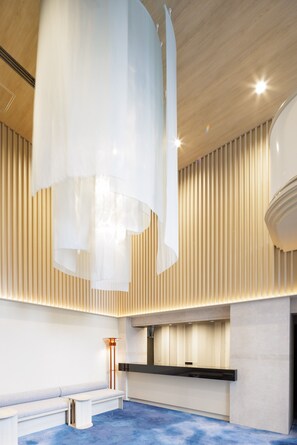 A modern reception area with a wooden ceiling, a reception desk, and a seating area. - HOTEL AMANEK Asakusa Sakurabashi (Tokyo)