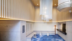 A modern interior with a blue floor, white walls, and a seating area with benches and stools. - HOTEL AMANEK Asakusa Sakurabashi (Tokyo)