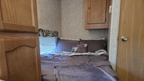 Una camera da letto con un letto, un armadio in legno e una porta.