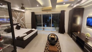 Habitación de hotel moderna con una cama grande, televisión, escritorio y balcón con vistas.