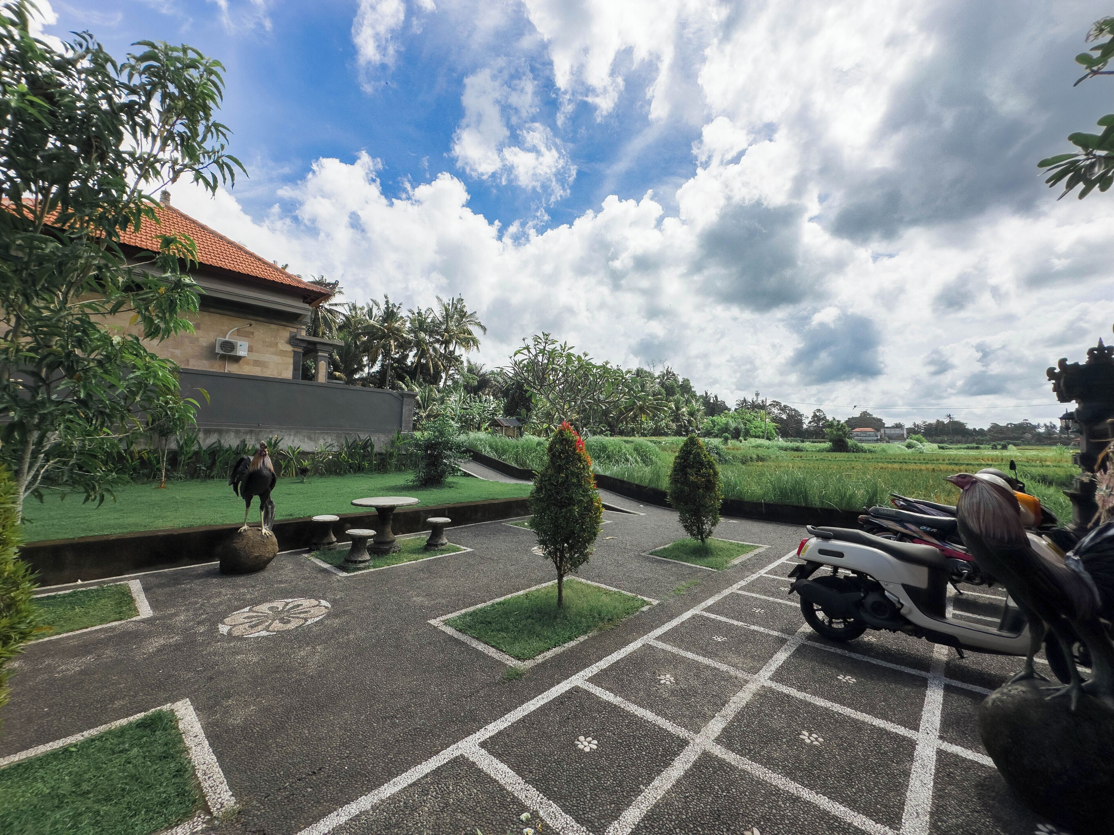 A parking area with a paved surface, a small table, and a few chairs.