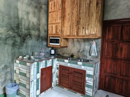 Uma cozinha compacta com armários de madeira, micro-ondas e painel de azulejos.