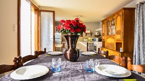 A dining table set with plates, glasses, and a vase of flowers. - House in Périgord near Medieval Villages (Prats du Périgord)