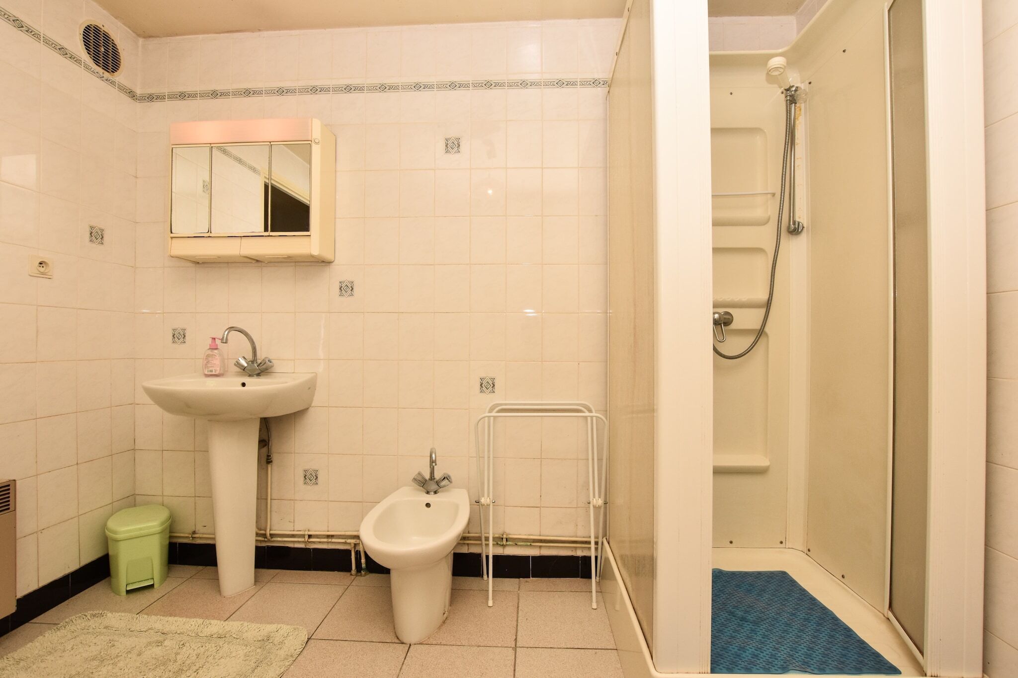 Un baño con lavabo, bidé, espejo y ducha.
