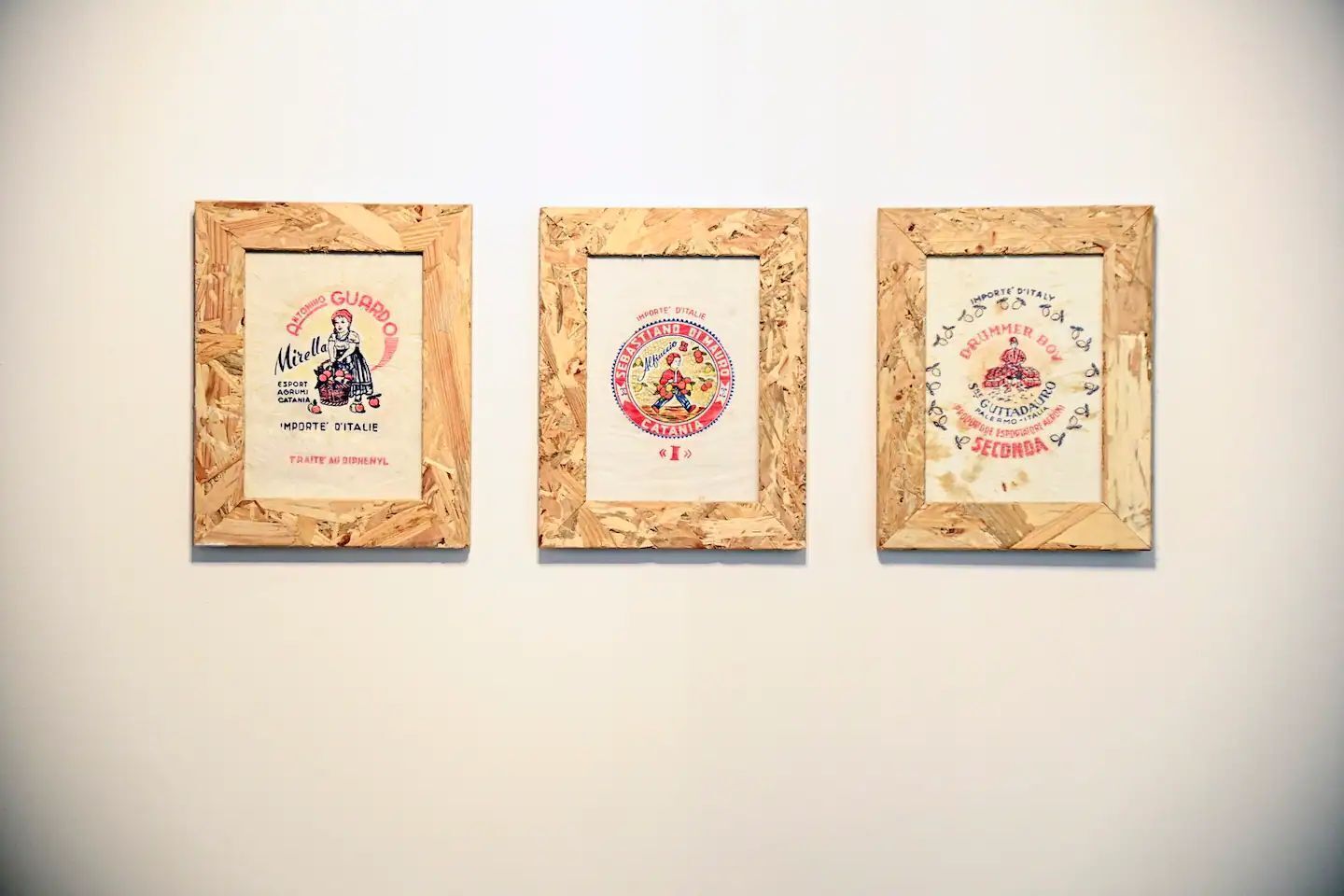 Three framed artworks with text and illustrations, mounted on a wall.