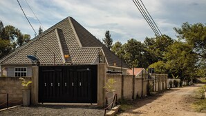 Il s’agit d’une propriété résidentielle dotée d’une entrée sécurisée par un portail, d’une allée et d’une maison avec un toit en pente.