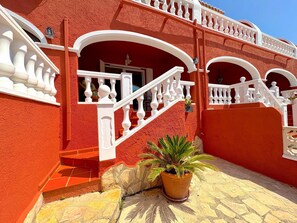 Un bâtiment rouge avec des balcons blancs et un escalier.