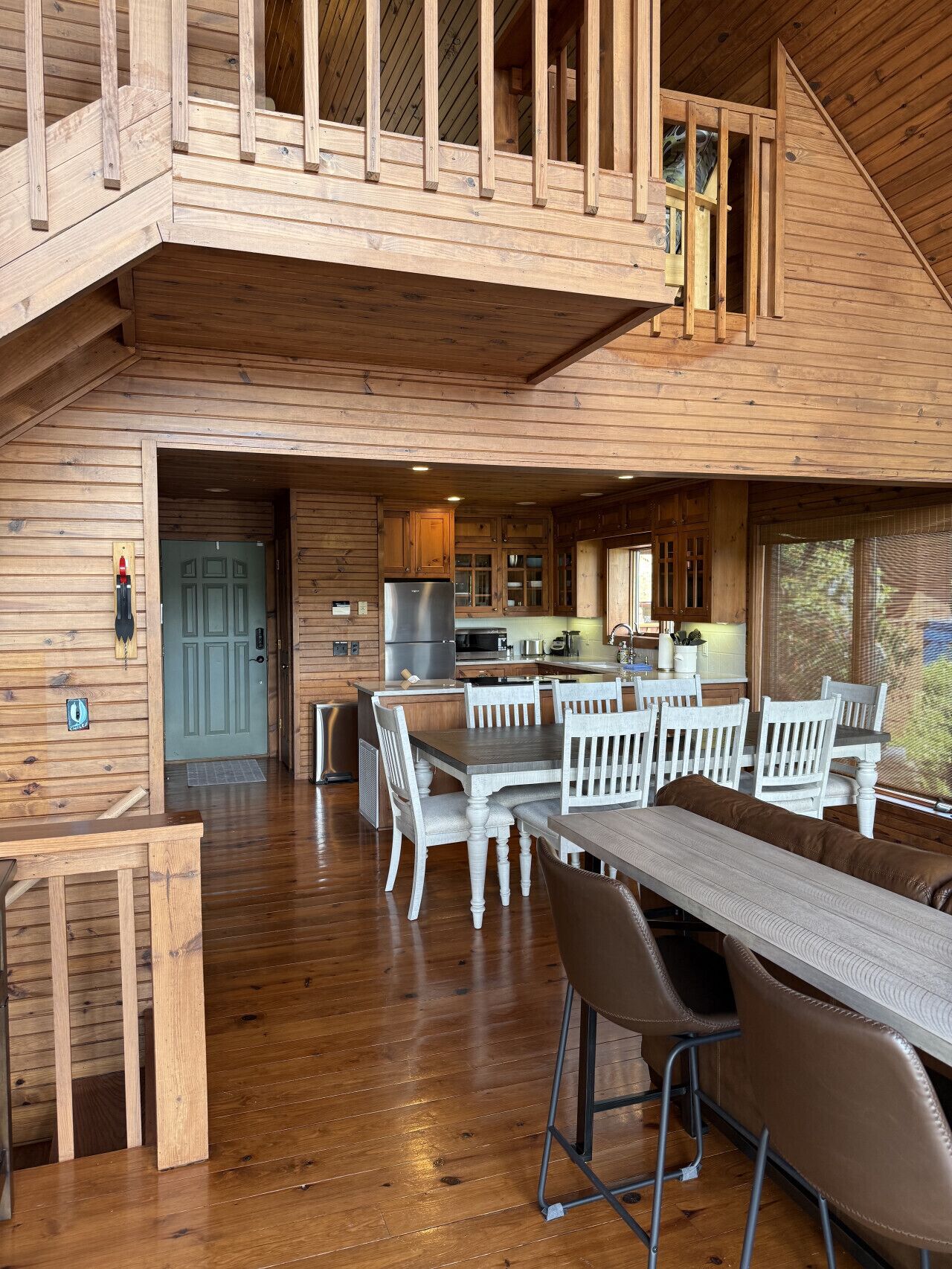 Eine geräumige Holzdiele mit Essbereich, Küche und Balkon.