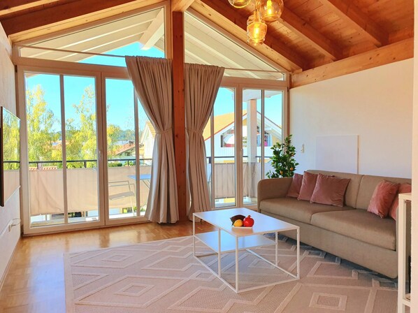 Amplia sala de estar con un sofá, una mesa de centro y vistas a través de amplias ventanas.