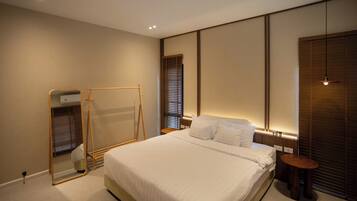 A modern bedroom with a large bed, bedside tables, a mirror, and a wardrobe.