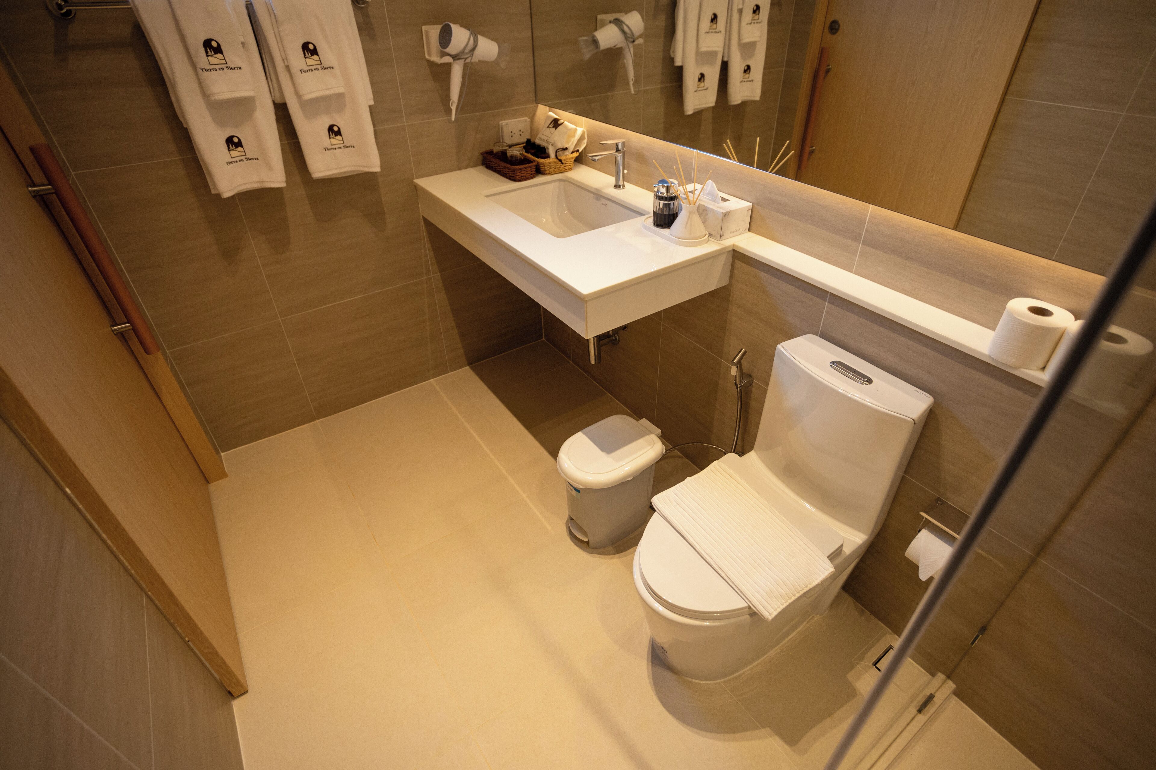 Ein modernes Badezimmer mit einem weißen Waschbecken, einer Toilette und einer Duschkabine.