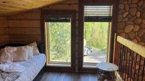 Una camera accogliente con un letto, un piccolo tavolo rotondo e un muro in pietra.