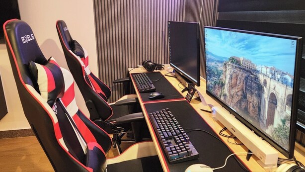 A gaming setup with two monitors, a keyboard, and two gaming chairs. - Polo Hotel (Incheon)