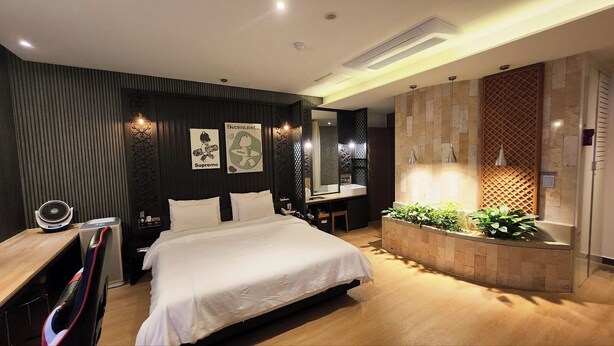 A modern bedroom with a large bed, a desk, and a vanity area. - Polo Hotel (Incheon)