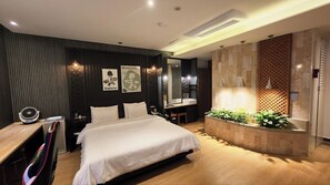 Um quarto moderno com uma cama grande, uma escrivaninha e um espaço para toucador.