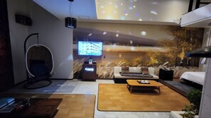 Uma sala de estar moderna com um sofá, uma mesa de centro e uma televisão.