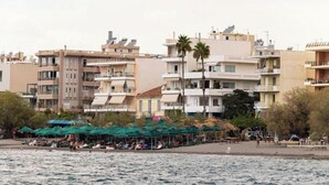 Et kysthotel med flere etager, udendørs siddepladser og udsigt til stranden.