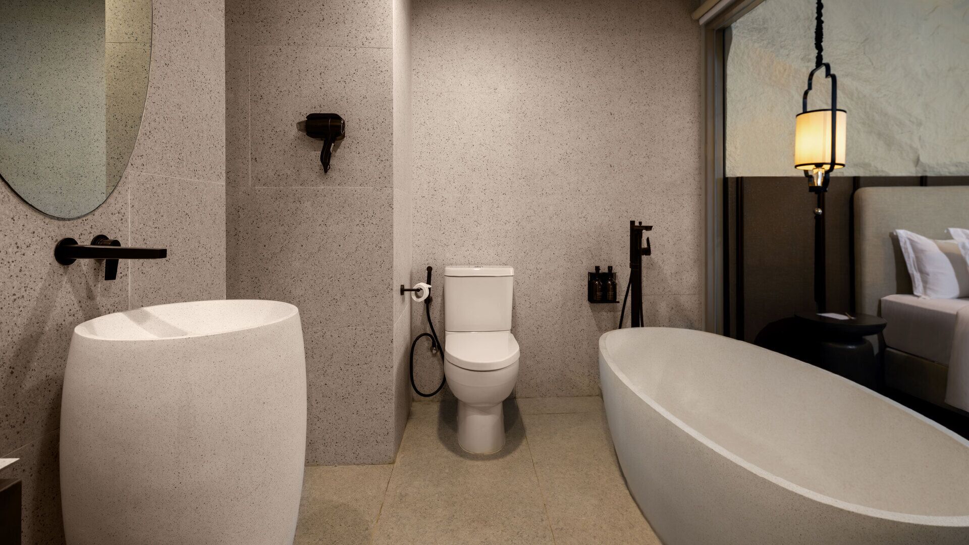 A modern bathroom with a freestanding bathtub, a large sink, and a toilet.