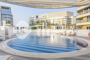 A modern hotel with a large pool area, outdoor seating, and contemporary architecture. - Bloomfields Coastal Calm 1BR Ajwan Soul (Abu Dhabi)