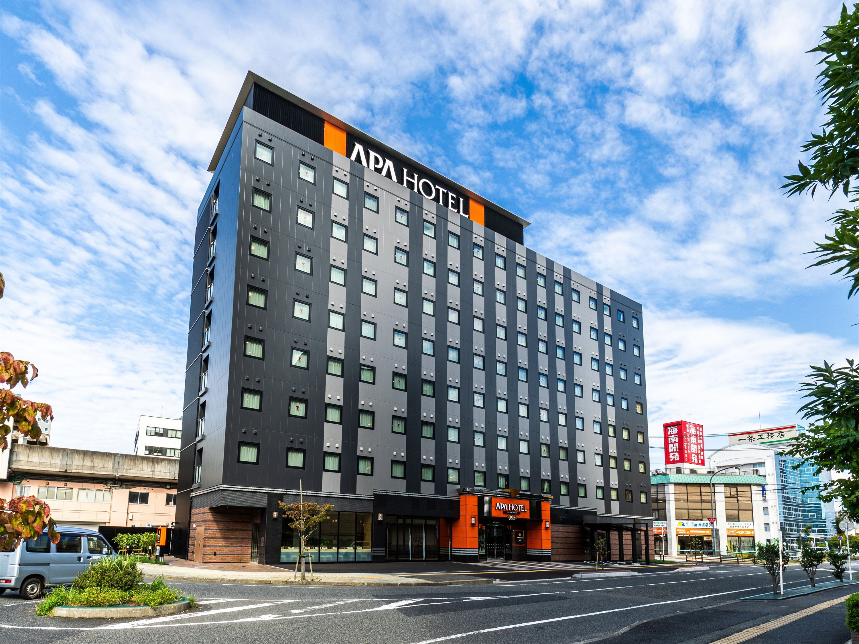 Moderni hotellirakennus, jonka julkisivussa on suuri, huomiota herättävä kyltti, jossa lukee ”APA HOTEL”.