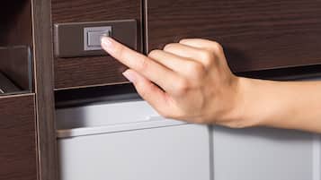 A hand pressing a button on a wooden panel above a white appliance.