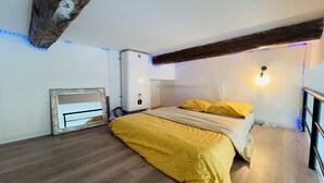 Une chambre à coucher avec un lit, un radiateur et un luminaire fixé au mur.