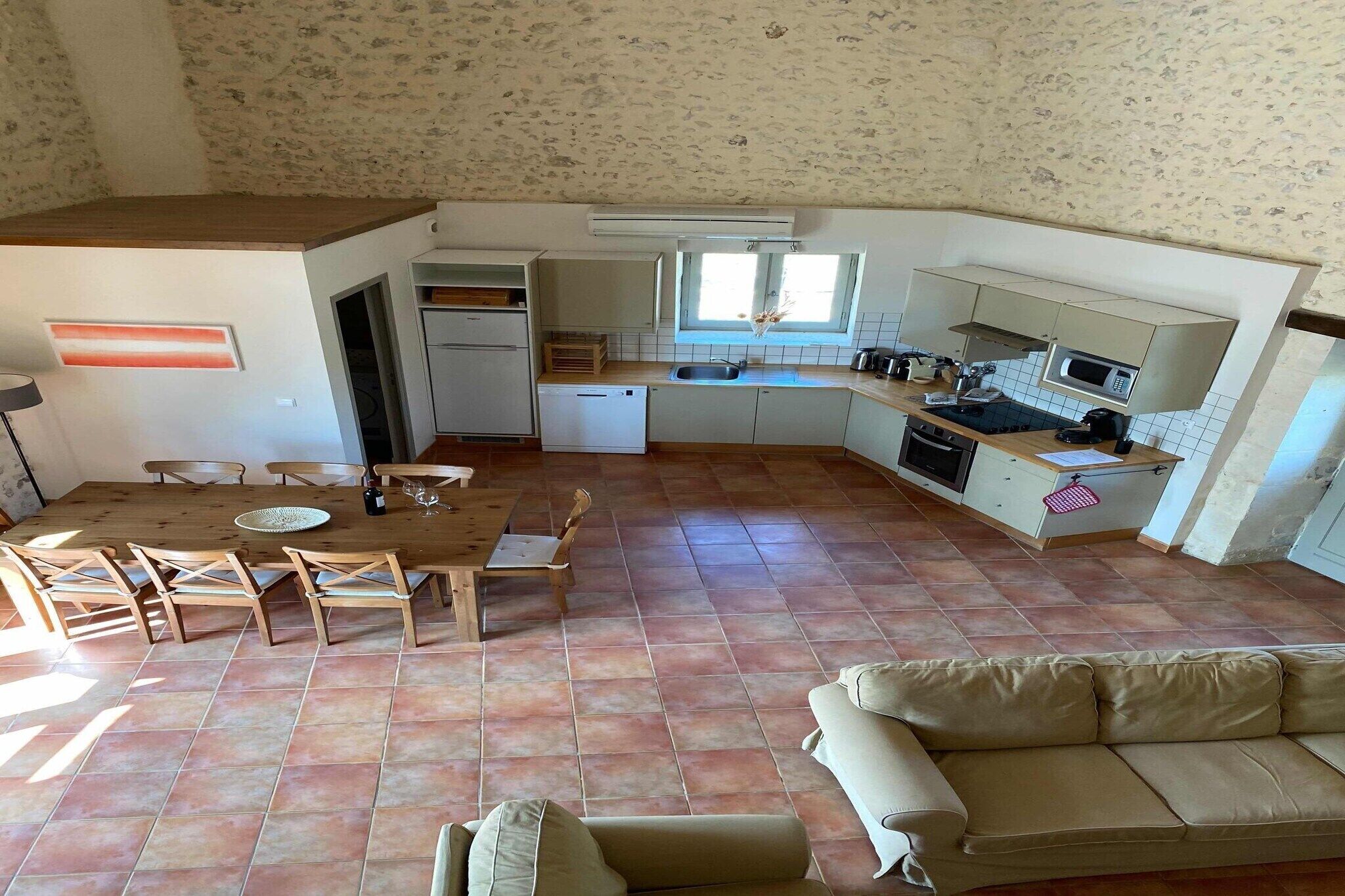A compact kitchen with a dining area, a built-in oven, and a microwave.
