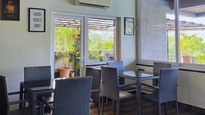 A modern indoor seating area with wicker furniture, an air conditioning unit, and a ceiling fan.