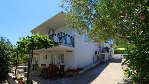 A two-story building with a balcony, outdoor seating, and a garden area. - Apartments Neven - Two Bedroom Apartment with Terrace and Partial Sea View (A1) (Drace)